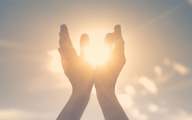 hands up to the sun representing mind, body and spirit
