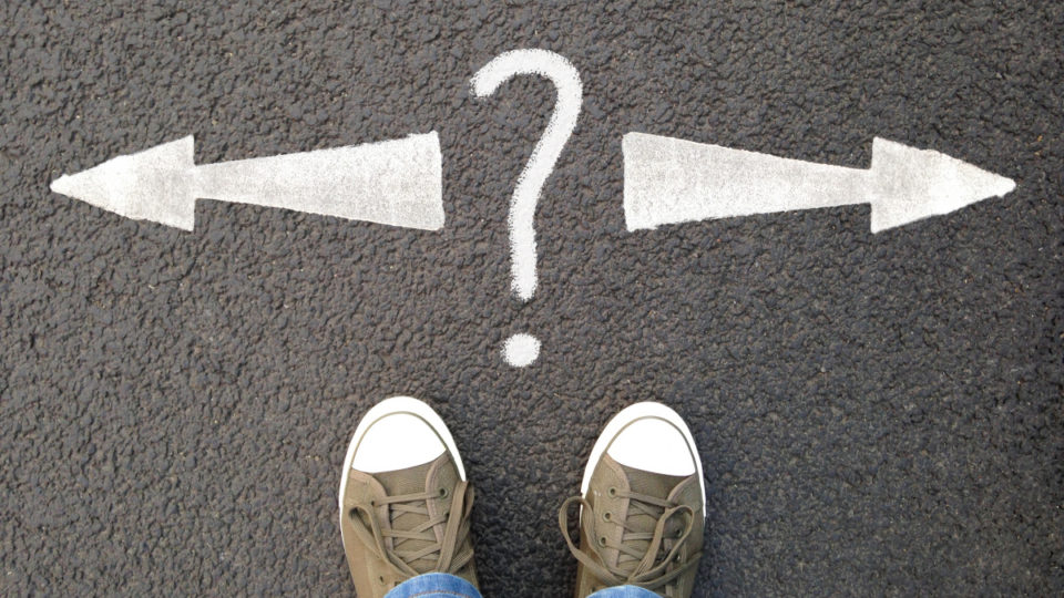 Feet standing on road with arrows representing motivation